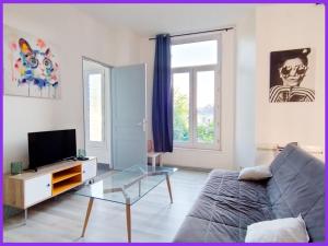 uma sala de estar com um sofá e uma televisão em 02 L Aparté By Fanny S em Saint-Quentin