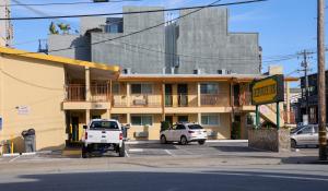a building with two cars parked in a parking lot at Greenwich Inn in San Francisco