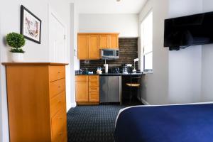 ein Hotelzimmer mit einer Küche mit einem Bett und einem Zimmer in der Unterkunft Cozy Studio in Downtown Boston, #46 in Boston