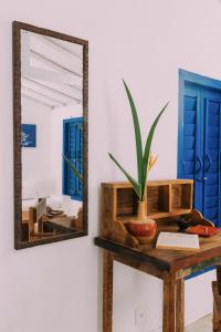 un espejo en una mesa con una planta. en Pousada Lagoa, en Caraíva