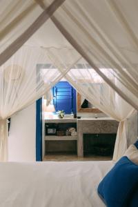 1 dormitorio con 1 cama blanca y ventana en Pousada Lagoa, en Caraíva