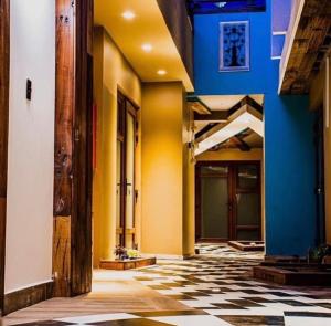 un pasillo con paredes amarillas y azules y suelo a cuadros en Hotel boutique, en La Serena