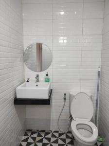 y baño con lavabo, aseo y espejo. en Villa BNA Curug Nangka Taman Sari Bogor, en Cibeunjing