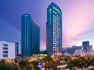 Holiday Inn Hangzhou Gongshu by IHG في هانغتشو: مبنى شاهق عليه لافتة في مدينة