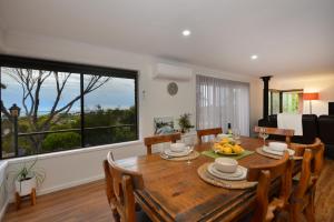 ein Esszimmer mit einem Tisch und Stühlen sowie einem großen Fenster in der Unterkunft Jacks Kangaroo Island in Kingscote