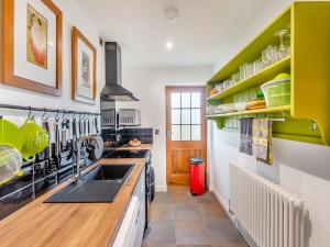 a kitchen with green cabinets and a sink at The Sanctuary in Sleaford