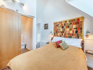 a bedroom with a bed with a large orange bedspread at The Sanctuary in Sleaford