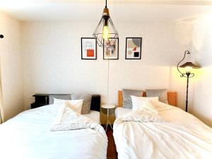 Duas camas sentadas uma ao lado da outra num quarto em 民宿にしかぐら em Higashikawa