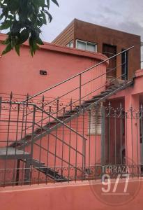 a staircase on the side of a pink building at Loft Terraza 9I7 Cochera en Excelente Ubicación in Villa Mercedes
