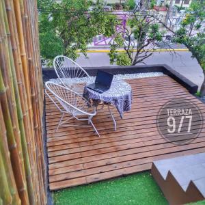 une table et des chaises sur une terrasse munie d'un ordinateur portable dans l'établissement Loft Terraza 9I7 Cochera en Excelente Ubicación, à Villa Mercedes