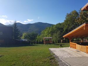 a yard with a gazebo and mountains in the background at Cabana Anisoara-Rimetea in Rimetea