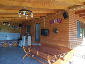 a room with a wooden wall with a table and a refrigerator at Cabana Anisoara-Rimetea in Rimetea