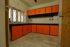 una cucina vuota con armadi arancioni e una finestra di ROHAN HOUSE a Nashik