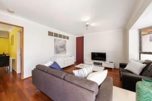 a living room with a couch and a tv at Swan River Applecross Heathcote Park 1BR Villa in Perth
