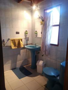 a bathroom with a sink and a toilet and a window at Hostal Tintica Buey Puerto Fuy in Puerto Fuy
