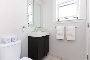 un bagno con lavandino, WC e specchio di A Stylish Stay w/ a Queen Bed, Heated Floors.. #26 a Brookline Altre 7 foto