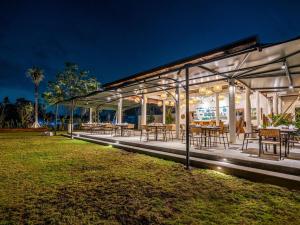 un edificio con mesas y sillas por la noche en The Pala Ubud by Elite Havens, en Bedahulu