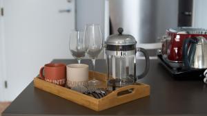 a wooden tray with wine glasses and a blender on a counter at Te Rukutai in Auckland