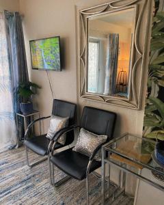 two chairs and a table in a room with a mirror at Stylish studio near Kuhio Beach in Honolulu