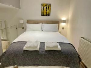a bedroom with a large bed with two towels on it at London Regent Studio Apartments in London