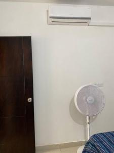 een slaapkamer met een ventilator naast een muur bij Apartamento central in Apartadó