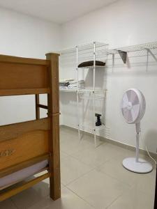 a bedroom with a bed and a fan and shelves at Apartamento central in Apartadó