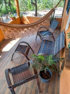 two chairs and a hammock on a porch with a plant at Residência Sol e Lar in Sao Jorge