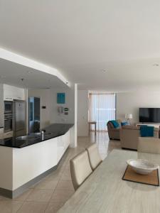 a large kitchen and living room with a table at Cilento Mooloolaba in Mooloolaba