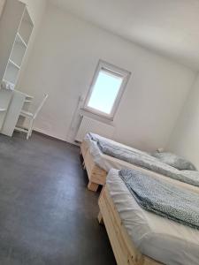 een kamer met 3 bedden en een raam bij hoteliving Apartments Gießen-Süd in Gießen