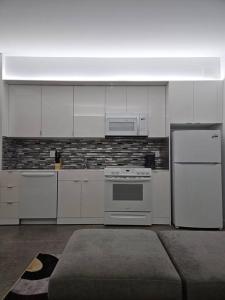 a kitchen with white cabinets and a stove and refrigerator at Tremont Smart 15 - A KCM Property in Cleveland