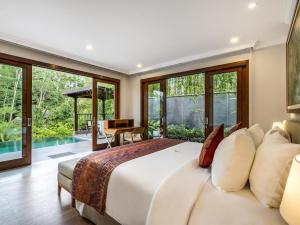 1 dormitorio con cama grande y ventana grande en The Pala Ubud by Elite Havens, en Bedahulu