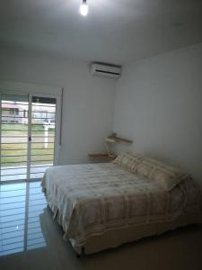 a white bedroom with a bed and a window at Casa cero stress in Salto