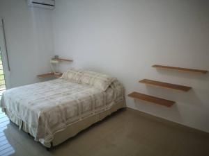 1 dormitorio con 1 cama en una habitación blanca en Casa cero stress, en Salto