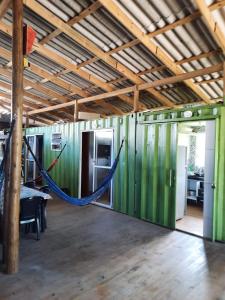 uma rede num quarto com paredes verdes em Recanto do Estaleiro em Ubatuba