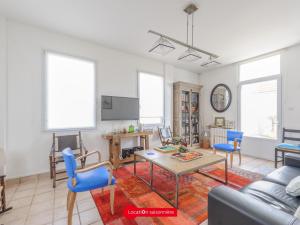 ein Wohnzimmer mit einem Tisch und blauen Stühlen in der Unterkunft Maison Châtelaillon-Plage, 5 pièces, 8 personnes - FR-1-535-19 in Châtelaillon-Plage