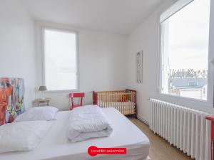 ein weißes Schlafzimmer mit 2 Betten und einem Fenster in der Unterkunft Maison Châtelaillon-Plage, 5 pièces, 8 personnes - FR-1-535-19 in Châtelaillon-Plage