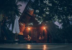 a group of people sitting at a table in front of a building at Lucy's Garden Hotel in Gili Air