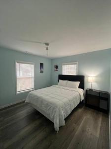 a bedroom with a large bed and two windows at Large 5 Bedroom Home Near Downtown Dalton in Dalton