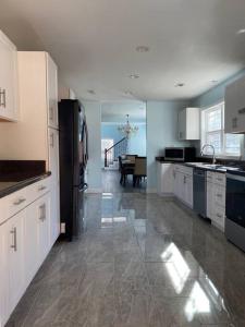 a kitchen with white cabinets and a black refrigerator at Large 5 Bedroom Home Near Downtown Dalton in Dalton