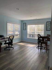 a living room with chairs and a table and two windows at Large 5 Bedroom Home Near Downtown Dalton in Dalton +6 photos