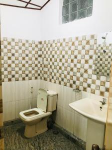 a bathroom with a toilet and a sink at Randiya Holiday Resort in Minneriya
