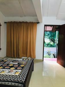 a bedroom with a bed in a room with a window at Randiya Holiday Resort in Minneriya