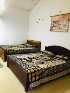 twee bedden in een kamer met een foto aan de muur bij Randiya Holiday Resort in Minneriya