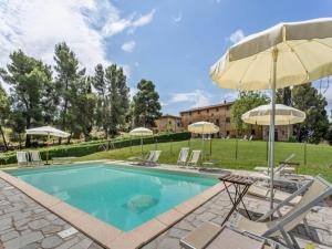 una piscina con sillas y sombrillas en Pet-friendly Holiday Home in Volterra with Swimming Pool, en Volterra