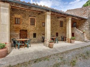 un patio con mesas y sillas frente a un edificio en Pet-friendly Holiday Home in Volterra with Swimming Pool, en Volterra