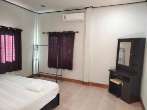 a bedroom with a bed and a dresser and a mirror at Bang Hon Homestay in Ko Yao Noi