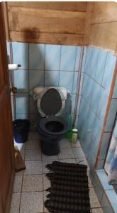 a bathroom with a black toilet in a room at Casa Manatí in Lívingston