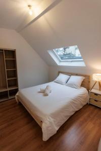 a bedroom with a large white bed with a skylight at Lafra - Charming & Intimate - Mon Groom in Troyes