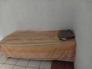 a bed sitting in a corner of a room at Hóspede se bem e com custo beneficio em Salvador in Salvador