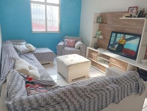 uma sala de estar com um sofá e uma televisão em Hóspede se bem e com custo beneficio em Salvador em Salvador
